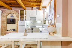 a kitchen with white cabinets and a table and chairs at Nell'antico ghetto ebraico in Ferrara