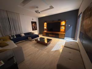 een woonkamer met een bank en een tv bij CasaBela in Juatuba