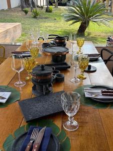 een houten tafel met borden en wijnglazen erop bij CasaBela in Juatuba