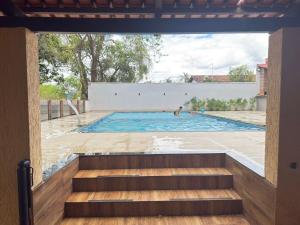een zwembad met een trap naar een huis bij CasaBela in Juatuba