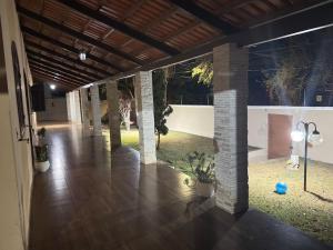 een grote kamer met een houten vloer en zuilen bij CasaBela in Juatuba