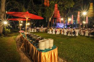 a table with plates on it with a crowd of people at Suan Bua Hotel & Resort in Ban Pong