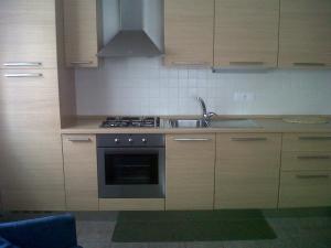 a kitchen with a sink and a stove top oven at Moderno appartamento e ampio garage in centro in Folgaria