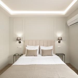 a bedroom with a large white bed with two lamps at ASTIKON Xenofontos Suites in Athens