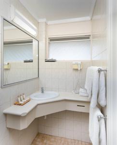 a white bathroom with a sink and a mirror at Hospitality Geraldton SureStay Collection by Best Western in Geraldton