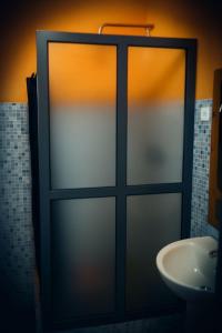 a glass door in a bathroom with a sink at Djabraba's Place in Vila Nova Sintra +9 photos