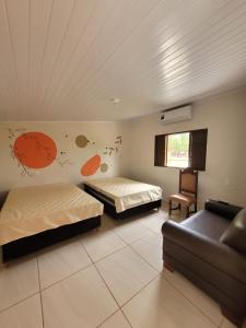 een slaapkamer met twee bedden en een bank erin bij Lago da Rosa in Olímpia