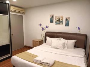 Un dormitorio con una cama grande con toallas. en Grand Apartment, en Dhaka