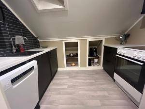 a kitchen with black cabinets and white appliances at Praktisk 3 roms leilighet in Bodø