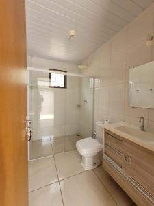 een badkamer met toilet, douche en wastafel bij Lago da Rosa in Olímpia