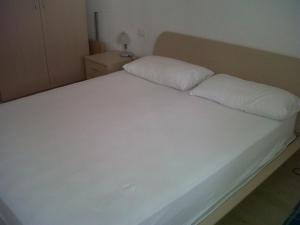 a white bed with two pillows on top of it at Moderno appartamento e ampio garage in centro in Folgaria +2 photos