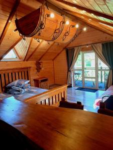 a room with a large bed in a wooden house at Rusnak Family in Synevyrsʼka Polyana
