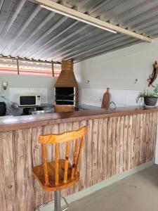 een keuken met een houten aanrecht en een houten stoel bij Lago da Rosa in Olímpia