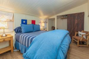 a bedroom with a blue bed and a chair at Ponderosa Cabin at O-Bar-O in Durango