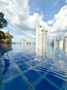 a infinity pool with a city in the background at Majestic Residence Klcc by Like Home in Kuala Lumpur
