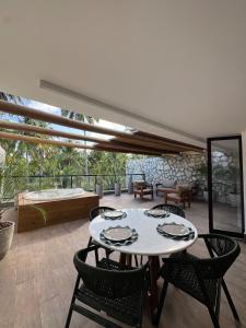 Habitación con mesa, sillas y patio. en Triplex Nalu - Sofisticação na Rota Ecológica de Milagres, en Porto de Pedras
