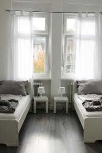 een slaapkamer met twee bedden en twee ramen bij RuhrpottImmo - Zentrale Wohnung in Iserlohn - bis zu 7 Pers in Iserlohn