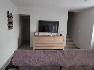a living room with a tv and a dresser at Chez sally in Le Bouchaud