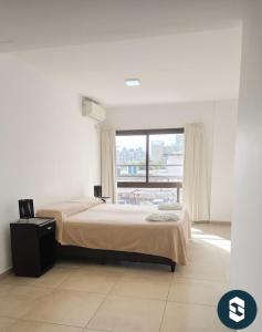 une chambre avec un lit et une grande fenêtre dans l'établissement Central Suites Hotel, à Villa Carlos Paz