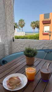 a table with a plate of food and an orange juice at Apartamento Marinas de Nerja in Nerja