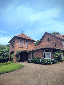 a brick house with a driveway in front of it at Cavalheiro de Monte Cristo in Ivoti