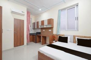 a bedroom with a large bed and a kitchen at Hotel O Radha Residency in Dahmi