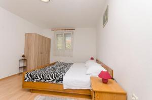 Un dormitorio con una cama con estampado de cebra y una lámpara roja. en Apartments Remi, en Nin