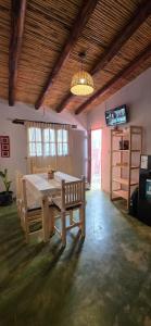 comedor con mesa de madera y banco en Departamentos Tilcara, en Tilcara