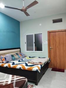 Un dormitorio con una cama y un ventilador de techo. en Rudraksh Homestay, en Ujjain