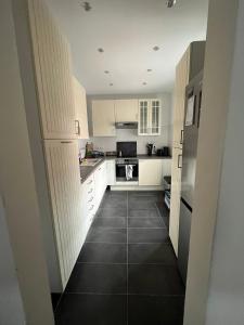 a kitchen with white cabinets and a black tile floor at Sunshine in Groß-Zimmern +1 photo