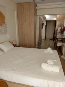 a bedroom with a large white bed with towels on it at Votsala in Loutraki +6 photos