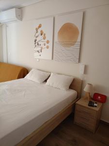 a bedroom with a bed and two pictures on the wall at Votsala in Loutraki
