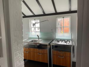 a kitchen with a sink and a stove at Solwerderstraat 12 - Hangende Keuken in Appingedam