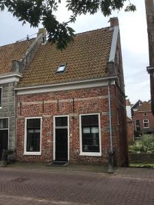 Un viejo edificio de ladrillo con techo en Solwerderstraat 12 - Hangende Keuken, en Appingedam