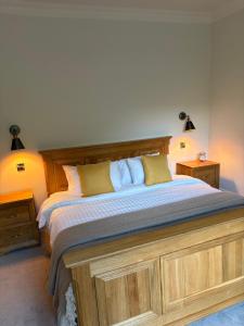 a bedroom with a large bed with a wooden headboard at The Boyne Arms in Burwarton