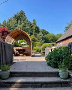 un arco de madera en un jardín con plantas en The Boyne Arms, en Burwarton