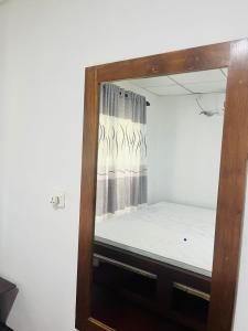 a mirror reflecting a bed in a room at Holiday Home Rathnaella in Hassalaka