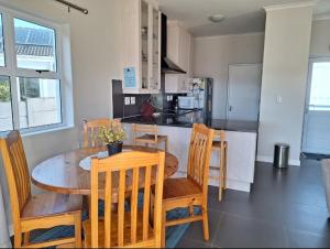 a kitchen and dining room with a wooden table and chairs at Chelmsford close in Oakdale