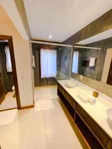 a bathroom with two sinks and a large mirror at Hura Vilas in Itarema