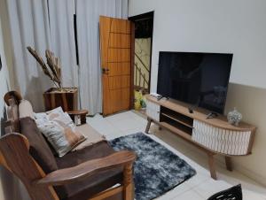 ein Wohnzimmer mit Flachbildfernseher und Sofa in der Unterkunft Apartmento duplex in Araxá