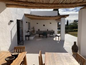 an outdoor patio with a table and a dining room at Les Agaves in Oulad el Madani