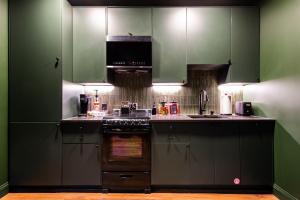a kitchen with green cabinets and a stove at Hollyhock Suite 505 in Louisville