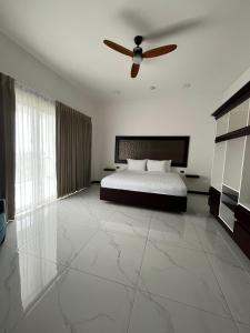 une chambre avec un lit et un ventilateur de plafond dans l'établissement Sanctuarium Hotel, à Fortuna