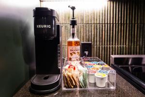 a bottle of wine and some cups on a counter at Hollyhock Suite 505 in Louisville +7 photos