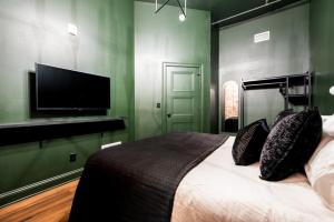 a bedroom with a bed and a flat screen tv at Hollyhock Suite 505 in Louisville