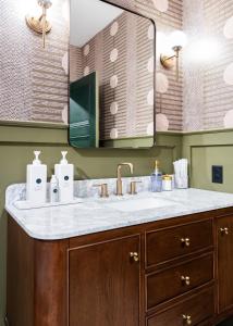 a bathroom with a sink and a mirror at Hollyhock Suite 505 in Louisville