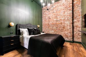 a bedroom with a bed and a brick wall at Hollyhock Suite 505 in Louisville