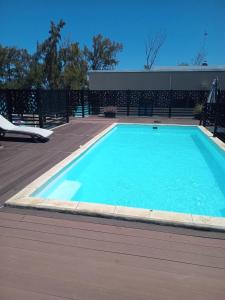 una gran piscina azul en una terraza de madera en Shanti Haveli Beachfront Appt, en Flic en Flac