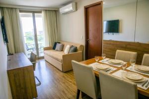 a living room with a table with chairs and a couch at Rio Centro Stay in Rio de Janeiro