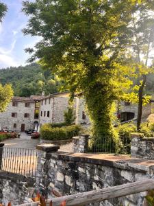 a large tree in front of a stone building at Le Boccede Country House B&B in Villa Minozzo